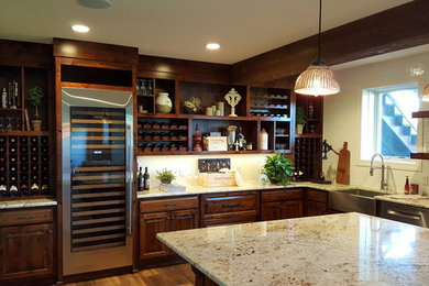 Example of a large classic l-shaped home bar design in Kansas City with an undermount sink, raised-panel cabinets, dark wood cabinets and granite countertops
