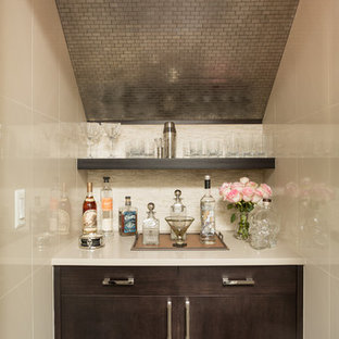 Imagen de bar en casa lineal, actual, pequeño, sin pila, con puertas de armario de madera en tonos medios, suelo de madera oscura, encimera de cuarzo compacto, salpicadero beige, salpicadero de azulejos de piedra y armarios con paneles lisos