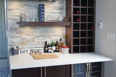 Example of a transitional home bar design in Vancouver with shaker cabinets, dark wood cabinets, quartz countertops, white countertops and stone tile backsplash