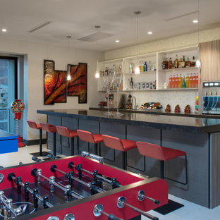 Immagine di un grande bancone bar contemporaneo con lavello sottopiano, top in superficie solida, paraspruzzi bianco, top nero, ante lisce, ante grigie e pavimento grigio