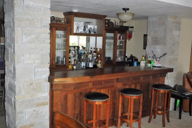 Inspiration for a mid-sized timeless galley ceramic tile seated home bar remodel in Milwaukee with glass-front cabinets, dark wood cabinets, wood countertops and mirror backsplash