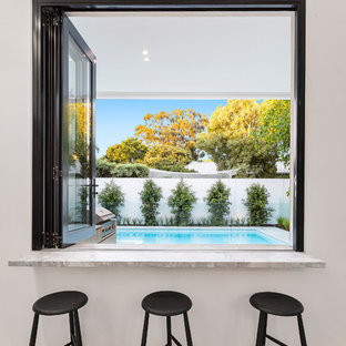 Foto di un bancone bar minimalista di medie dimensioni con top in marmo, pavimento in cemento, pavimento bianco e top grigio