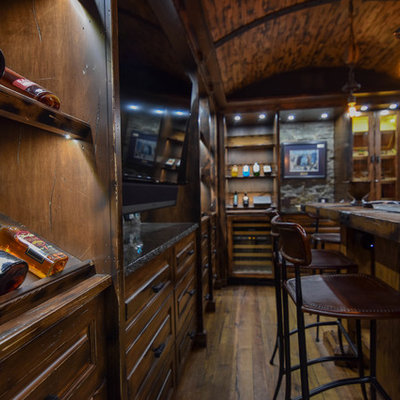 Inspiration for a large rustic u-shaped medium tone wood floor and brown floor seated home bar remodel in Edmonton with raised-panel cabinets, dark wood cabinets, wood countertops, brown backsplash and wood backsplash