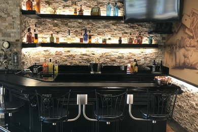 This is an example of a medium sized urban u-shaped breakfast bar in Other with brown splashback, stone tiled splashback, concrete flooring, brown floors and black worktops.