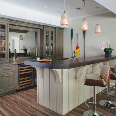 Seated home bar - coastal porcelain tile seated home bar idea in Atlanta with wood countertops, medium tone wood cabinets and glass-front cabinets