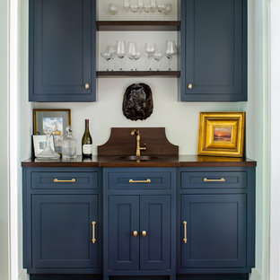 Esempio di un angolo bar con lavandino tradizionale con lavello sottopiano, ante in stile shaker, ante blu, top in legno, pavimento in legno massello medio e top marrone