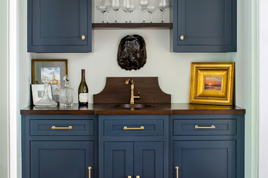 Inspiration for a timeless single-wall medium tone wood floor wet bar remodel in Atlanta with an undermount sink, shaker cabinets, blue cabinets, wood countertops and brown countertops