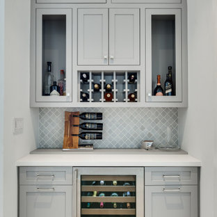 Modelo de bar en casa con fregadero lineal, costero, pequeño, con puertas de armario grises, encimera de azulejos, salpicadero verde, salpicadero con mosaicos de azulejos, suelo gris, encimeras blancas, armarios estilo shaker y suelo de baldosas de porcelana