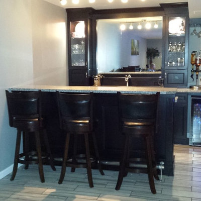 Inspiration for a small contemporary single-wall porcelain tile seated home bar remodel in St Louis with an undermount sink, raised-panel cabinets, black cabinets and granite countertops