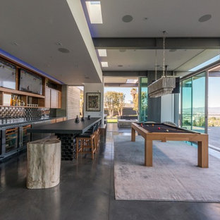 Modelo de bar en casa con barra de bar de galera, actual, con armarios abiertos, puertas de armario de madera oscura y suelo gris