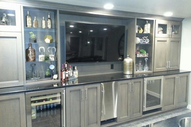 Ejemplo de bar en casa con fregadero lineal clásico grande con fregadero encastrado, armarios estilo shaker, puertas de armario de madera clara y suelo de madera clara