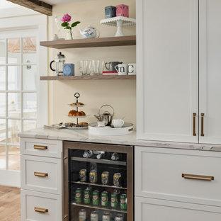 Ispirazione per un grande angolo bar country con ante in stile shaker, ante bianche, top in quarzo composito, paraspruzzi bianco, paraspruzzi in quarzo composito, parquet chiaro, pavimento marrone e top bianco