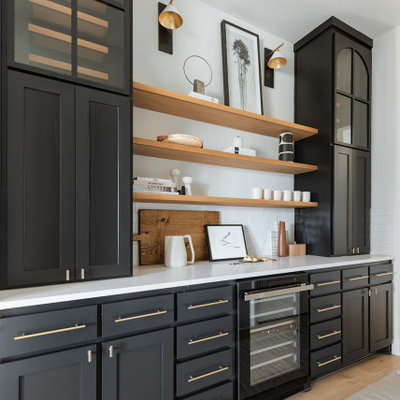 Mid-sized minimalist galley light wood floor home bar photo in Dallas with no sink, shaker cabinets, black cabinets, white backsplash and white countertops