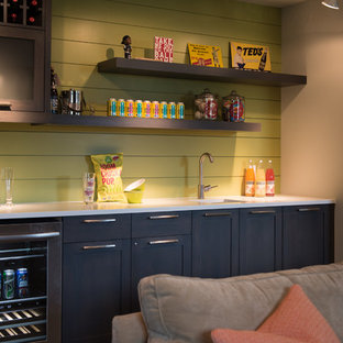 Imagen de bar en casa con fregadero lineal, retro, con fregadero bajoencimera, armarios estilo shaker, puertas de armario negras, salpicadero verde y encimeras blancas