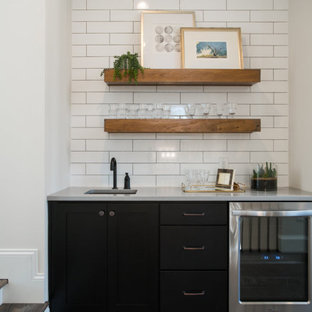 Foto di un piccolo angolo bar con lavandino classico con lavello sottopiano, ante in stile shaker, ante nere, top in quarzo composito, paraspruzzi bianco, paraspruzzi con piastrelle in ceramica, pavimento in legno massello medio, pavimento marrone e top grigio
