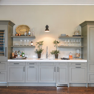 Immagine di un angolo bar con lavandino chic con lavello sottopiano, ante con riquadro incassato, ante verdi, parquet scuro, pavimento marrone e top bianco
