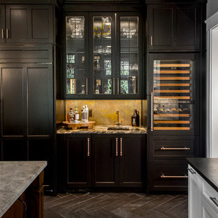 Cette image montre un très grand bar de salon traditionnel avec un placard à porte affleurante, un sol en carrelage de porcelaine, un évier encastré, un plan de travail en granite, une crédence multicolore et des portes de placard noires.