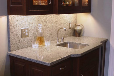 Small elegant single-wall wet bar photo in Indianapolis with an undermount sink, glass-front cabinets, dark wood cabinets, granite countertops, gray backsplash and stone slab backsplash