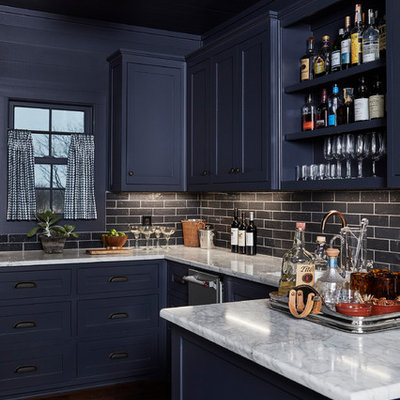 Example of a mid-sized beach style u-shaped dark wood floor and brown floor wet bar design in Dallas with shaker cabinets, blue cabinets, black backsplash, subway tile backsplash, an undermount sink, marble countertops and gray countertops