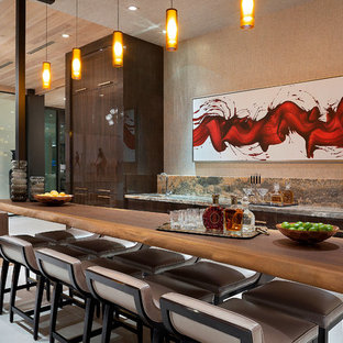 Immagine di un bancone bar design con lavello sottopiano, ante lisce, ante in legno bruno e pavimento grigio