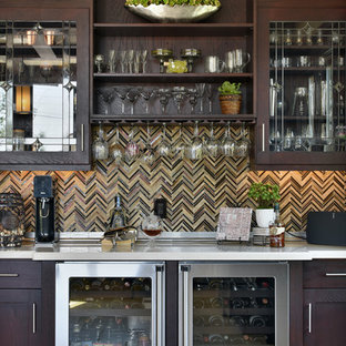Modelo de bar en casa tradicional, grande, con puertas de armario de madera en tonos medios, salpicadero multicolor y armarios tipo vitrina