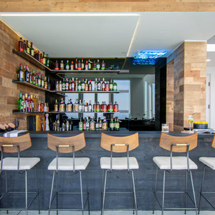 Esempio di un angolo bar industriale con mensole sospese, pavimento grigio e top grigio