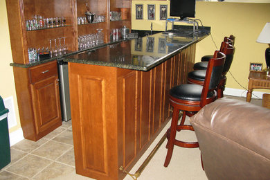 Mid-sized elegant carpeted seated home bar photo in Chicago with raised-panel cabinets and medium tone wood cabinets