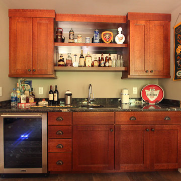 Home bar with quarter sawn oak stained cabinets and black granite countertops