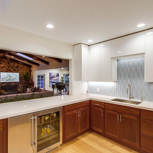 Esempio di un grande angolo bar moderno con ante con riquadro incassato, ante in legno scuro, top in quarzo composito, paraspruzzi blu, paraspruzzi con piastrelle di vetro, parquet chiaro, pavimento beige e top bianco