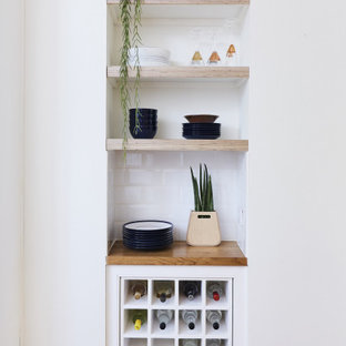 Small scandinavian single-wall home bar in London with wood worktops, white splashback, no sink, open cabinets and metro tiled splashback.