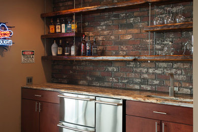 Wet bar - mid-sized industrial single-wall wet bar idea in Wichita with an undermount sink, flat-panel cabinets, dark wood cabinets, granite countertops, red backsplash and brick backsplash