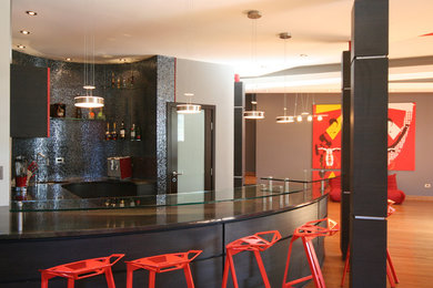 Diseño de bar en casa con barra de bar contemporáneo de tamaño medio con armarios con paneles lisos, puertas de armario rojas, encimera de granito, salpicadero de azulejos de vidrio y suelo de madera en tonos medios