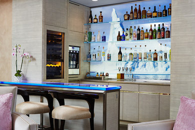 Example of a mid-sized transitional l-shaped dark wood floor seated home bar design in Minneapolis with flat-panel cabinets, beige cabinets, glass countertops and multicolored backsplash