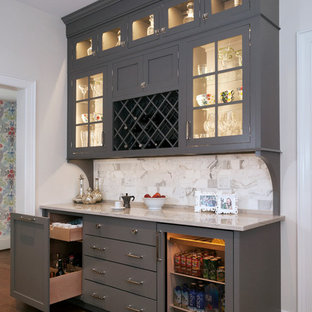 Imagen de bar en casa lineal, tradicional, sin pila, con armarios tipo vitrina, puertas de armario grises, encimera de cuarcita, salpicadero de azulejos de piedra, suelo de madera oscura, salpicadero multicolor y suelo marrón