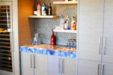 Home bar - mid-sized home bar idea in Atlanta with flat-panel cabinets and marble countertops