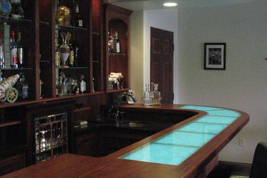 Foto de bar en casa con barra de bar en L actual de tamaño medio con fregadero bajoencimera, armarios abiertos, puertas de armario de madera en tonos medios y encimera de madera