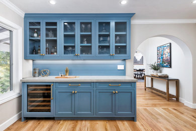 Inspiration for a mid-sized farmhouse single-wall medium tone wood floor and brown floor home bar remodel in San Francisco with beaded inset cabinets, blue cabinets, quartz countertops, blue backsplash, wood backsplash and gray countertops
