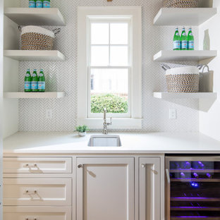 Ejemplo de bar en casa lineal, tradicional renovado, de tamaño medio, con puertas de armario blancas, encimera de cuarzo compacto, salpicadero blanco, salpicadero de azulejos de porcelana, suelo de madera clara, encimeras blancas, fregadero bajoencimera, armarios estilo shaker y suelo beige
