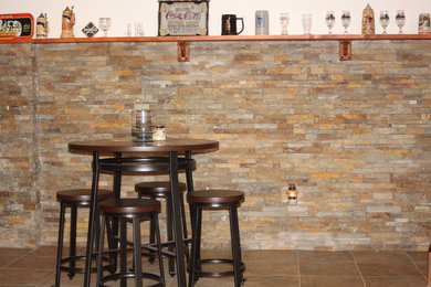 Photo of a medium sized rustic home bar in Philadelphia with vinyl flooring, stone tiled splashback and brown floors.