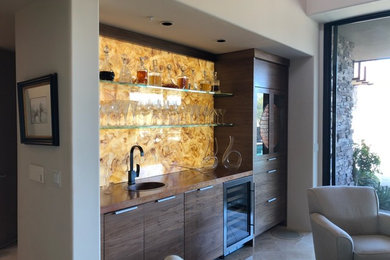 Example of a mid-sized trendy single-wall wet bar design in Phoenix with a drop-in sink, brown cabinets, wood countertops, yellow backsplash and stone slab backsplash