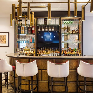Inspiration for a medium sized classic single-wall breakfast bar in London with open cabinets, mirror splashback, light hardwood flooring, beige floors and black worktops.