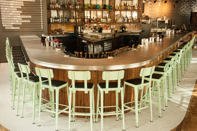 Seated home bar - large industrial u-shaped dark wood floor seated home bar idea in Other with open cabinets, dark wood cabinets and zinc countertops