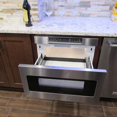 Example of a large trendy galley porcelain tile wet bar design in New York with an undermount sink, shaker cabinets, dark wood cabinets, granite countertops, multicolored backsplash and stone tile backsplash