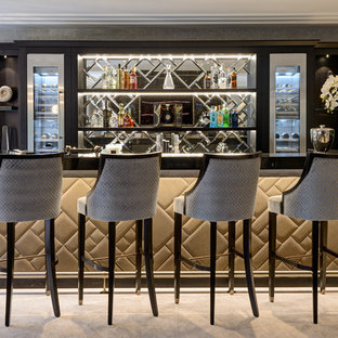 Photo of a large contemporary single-wall breakfast bar in Surrey with open cabinets, wood worktops, mirror splashback, grey floors and black worktops.