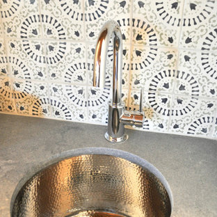 Immagine di un piccolo angolo bar con lavandino stile rurale con lavello sottopiano, ante a filo, ante verdi, top in quarzo composito, paraspruzzi multicolore, paraspruzzi con piastrelle in terracotta, pavimento in laminato, pavimento marrone e top grigio