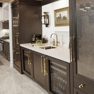 Idee per un angolo bar con lavandino classico di medie dimensioni con lavello sottopiano, ante di vetro, ante in legno bruno, top in quarzo composito, paraspruzzi grigio, paraspruzzi in quarzo composito, pavimento in travertino, pavimento grigio e top grigio