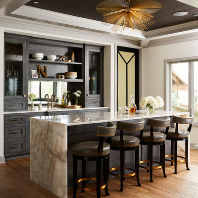 Example of a huge transitional galley medium tone wood floor and brown floor wet bar design in Minneapolis with an undermount sink, recessed-panel cabinets, dark wood cabinets, quartzite countertops, mirror backsplash and white countertops
