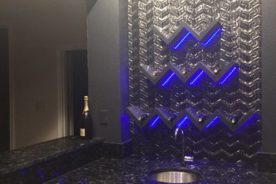 Photo of a medium sized modern l-shaped wet bar in Dallas with a submerged sink, shaker cabinets, grey cabinets, granite worktops, black splashback and metal splashback.