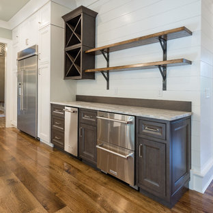 Wet bar - mid-sized farmhouse single-wall dark wood floor and brown floor wet bar idea in Atlanta with no sink, recessed-panel cabinets, dark wood cabinets, granite countertops, white backsplash and wood backsplash