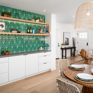 Ispirazione per un angolo bar senza lavandino contemporaneo di medie dimensioni con ante lisce, ante bianche, top in quarzo composito, paraspruzzi verde, paraspruzzi con piastrelle a mosaico, pavimento in legno massello medio e top grigio